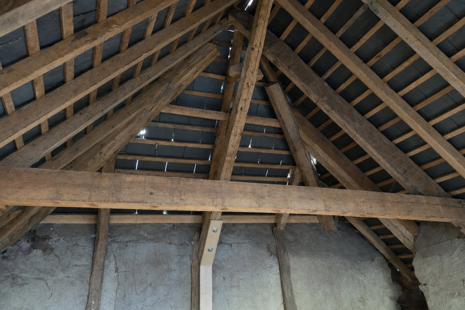 Charpente traditionnelle en bois sous une toiture en ardoise près de Rennes — chevron réparé par MD Toiture