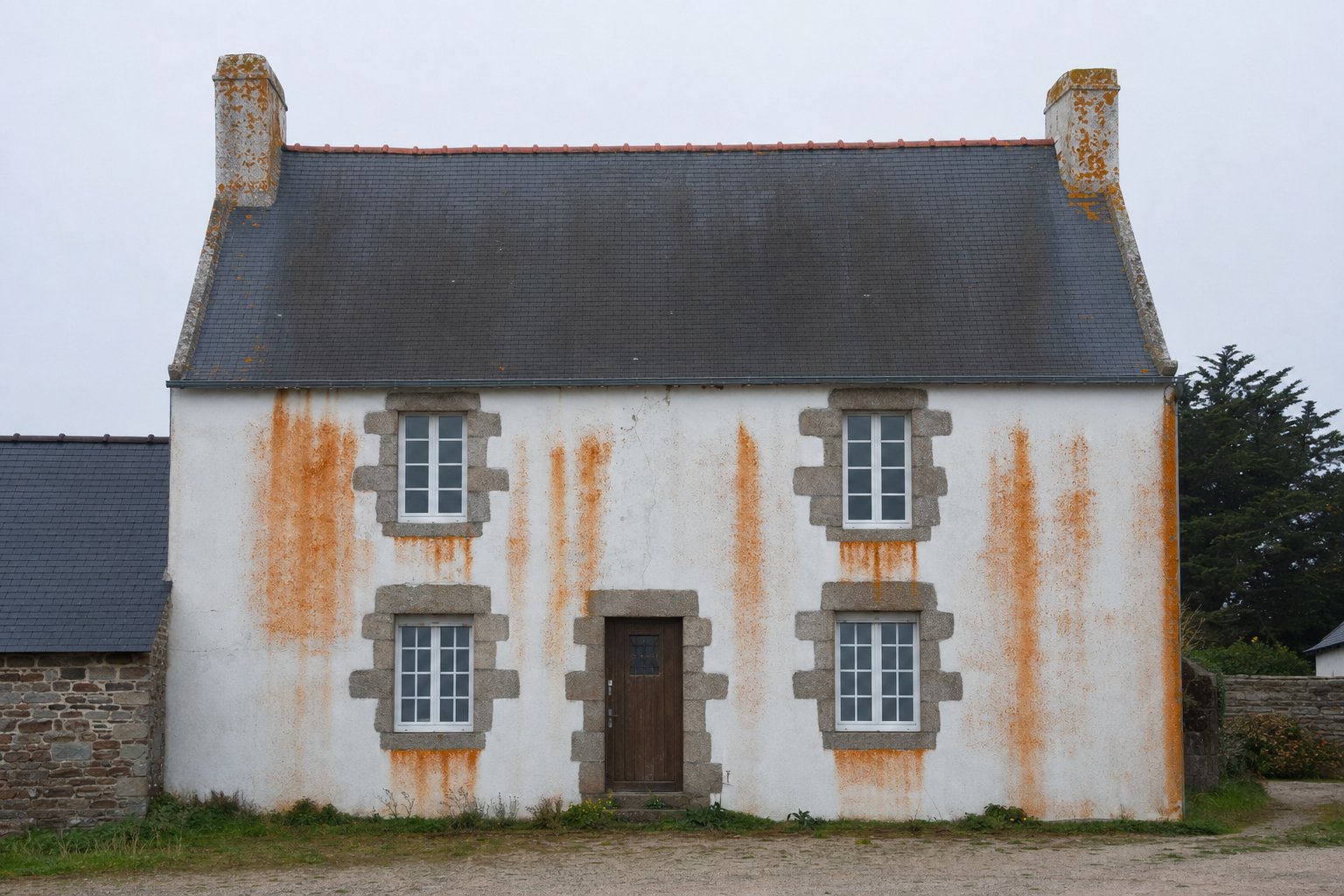 Nettoyage façade Rennes — traces rouges et vert-de-gris sur crépi breton traitement MD Toiture